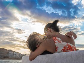 A couple shares a romantic moment on a boat at sunset, creating a perfect backdrop for love and celebration on the water.