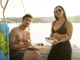 A couple enjoys a romantic dinner on a boat at sunset, savoring delicious seafood while soaking in the beautiful views — perfect for a memorable evening on the water.
