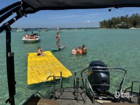 A fun day at the sandbar with friends enjoying swimming, paddleboarding, and relaxing on a floating mat — a perfect summer getaway on the water.