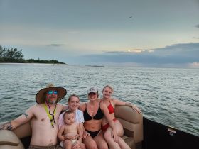 A joyful family enjoys a relaxing moment on a boat, capturing the essence of summer fun and togetherness on the water.