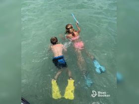 Two children enjoy snorkeling in clear waters, showcasing a fun and adventurous day on the water — perfect for family outings and aquatic exploration.