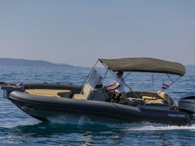 A speedboat glides through clear waters with a captain at the helm, showcasing the thrill of boating adventures on the open sea.