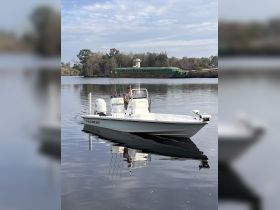 A fisherman navigates a Blazer Bay boat on calm waters, showcasing a perfect day for fishing and exploration.