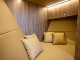A cozy cabin interior featuring comfortable seating and modern design elements, perfect for relaxation on a boat.