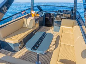 A stylish interior view of a luxury boat featuring comfortable seating and a well-equipped helm, perfect for relaxing while cruising on the water.