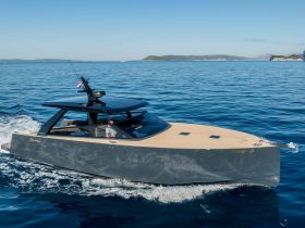 A sleek yacht glides through clear waters, showcasing its modern design and elegance while underway.