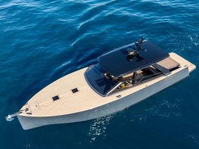 A stunning aerial view of a sleek yacht gliding through crystal-clear waters, showcasing its elegant design and modern features.
