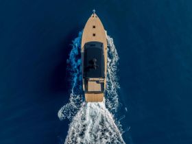 A stunning aerial view of a sleek yacht cruising through deep blue waters, showcasing its elegant design and smooth movement.