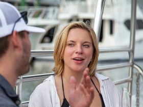 A woman engages in conversation on a boat, capturing the essence of socializing and enjoyment on the water.