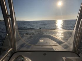 A stunning view from the helm of a boat, showcasing the shimmering water and sunlit horizon — perfect for a day on the water.