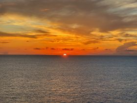 A stunning sunset over the ocean, providing a picturesque backdrop for evening boat cruises and romantic getaways.