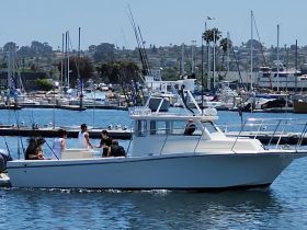 A lively group enjoys a day on the water aboard a fishing boat in the harbor, showcasing the perfect setting for a fun fishing adventure.