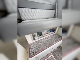 Interior view of a boat cabin featuring comfortable seating and organized storage, ideal for relaxing during trips on the water.