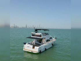 A stunning aerial view of a luxurious yacht anchored in calm waters, with a city skyline in the background, perfect for showcasing upscale boating experiences.