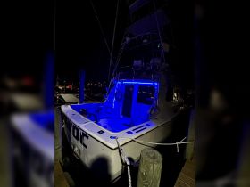 A striking view of a boat illuminated by blue lights at night, docked and ready for evening adventures.