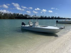 A center console boat docked in calm waters, surrounded by lush greenery — perfect for fishing or leisurely cruises.