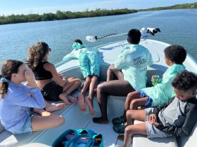 A group of children enjoys a boat ride, exploring the serene waters surrounded by lush greenery — a perfect adventure for young explorers.