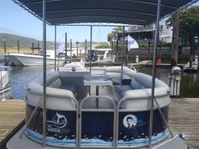 Interior view of a pontoon boat featuring comfortable seating, perfect for relaxing on the water. Ideal for family outings or group gatherings.