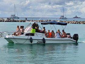A lively group enjoys a boat ride, showcasing the fun and camaraderie of on-water adventures in a beautiful setting.