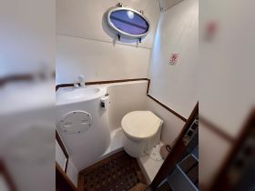 Interior view of a boat bathroom featuring a toilet and sink, designed for convenience on the water.