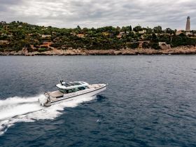 A sleek speedboat glides through the water, showcasing its design against a picturesque coastal backdrop — perfect for exploring scenic shorelines.