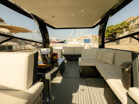 Interior view of a luxurious boat lounge area featuring comfortable seating and a stylish table, perfect for relaxing while enjoying the marina scenery.