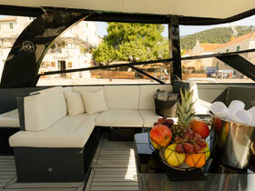 A stylish interior view of a boat's lounge area featuring comfortable seating and a vibrant fruit display, perfect for relaxing on the water.