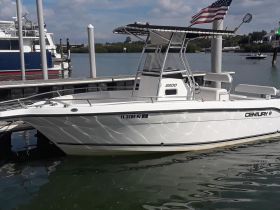 A pristine center console boat docked at the marina, showcasing its sleek design and ready for a day on the water.