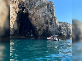 A scenic view of a boat navigating near a stunning rock formation, showcasing the beauty of coastal exploration and adventure.
