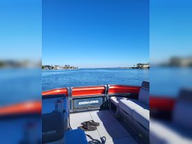 A cozy interior view of a boat showcasing comfortable seating and a serene water backdrop, perfect for relaxing on the water.