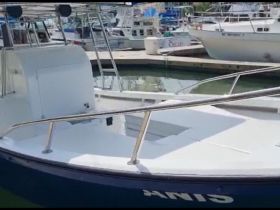 A close-up view of a boat docked at the marina, showcasing its sleek design and features, perfect for fishing or leisure outings.