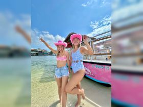 Two friends celebrate at the beach, showcasing their vibrant swimwear and enjoying a fun day in the sun — perfect for summer adventures and beach parties.