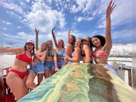 A lively group of friends celebrates on a boat, enjoying a sunny day at the beach — perfect for summer parties and memorable outings.