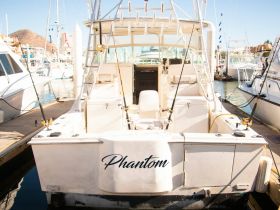 The rear view of the fishing boat 'Phantom' docked at the marina, showcasing its sleek design and fishing gear.