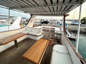 Interior view of a spacious boat cabin featuring comfortable seating and dining areas, perfect for relaxing while on the water.