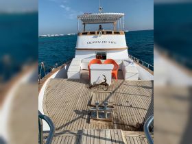 The interior of the 'Queen of Life' showcases a spacious deck with comfortable seating, perfect for relaxing while cruising on the open water.