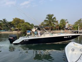 A group of people aboard a fishing boat, actively engaging in their fishing adventure. The vibrant surroundings and clear waters enhance the experience of a day out on the water.