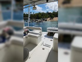 Interior view of a boat showcasing comfortable seating and a spacious layout, perfect for relaxing while enjoying the scenic waterfront.