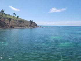 A serene view of a lush coastline meeting crystal-clear waters, perfect for showcasing the beauty of tropical destinations.