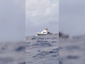 A fishing boat navigates through the open sea, showcasing its sturdy design and fishing gear, perfect for ocean adventures.