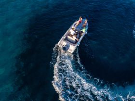 A lively group enjoys a day on the water aboard a boat, creating unforgettable memories as they navigate through the stunning blue waters.