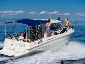 A lively group enjoys a day on the water aboard a sleek boat, showcasing the perfect summer adventure with friends.