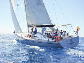 A lively group enjoys a sailing experience aboard the yacht 'SPHYNX', capturing the joy of family time on the water.