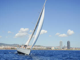 A sleek sailboat glides through the waters with a vibrant city skyline in the background, showcasing the perfect blend of adventure and urban beauty.