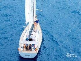 A lively group enjoys a sailing adventure aboard the yacht SPHYNX, capturing the essence of fun and celebration on the open water.