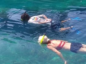 Two snorkelers explore the vibrant underwater world, enjoying a refreshing swim in crystal-clear waters — a perfect adventure for marine enthusiasts.