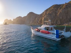 A beautiful yacht anchored near stunning rocky cliffs, showcasing the perfect setting for a coastal adventure.