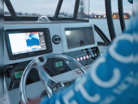 A close-up view of the helm and console of a boat, showcasing advanced navigation equipment and controls, perfect for boating enthusiasts and captains.