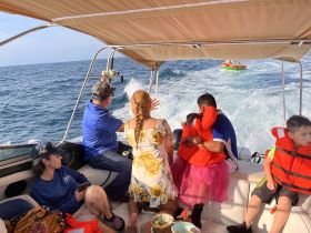 A joyful family enjoys a day on the water, with kids in life jackets and fun activities in the background — perfect for memorable boating adventures.