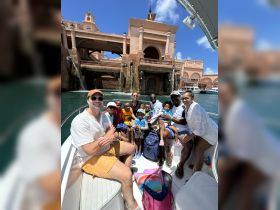 A joyful family group enjoys a boat ride near the stunning Atlantis resort, creating unforgettable memories together on the water.